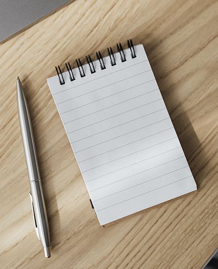 блокнот с записями и ручка рядом с ноутбуком